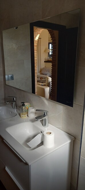 Ein Badezimmer mit zwei Waschbecken, einem Spiegel und einer Toilette.