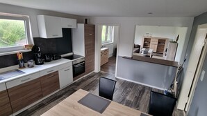 Una cucina moderna con isola centrale, mobili in legno e vista sull'esterno.