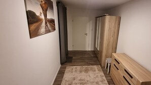 Un corridoio con una panca di legno, una porta e un quadro appeso al muro.