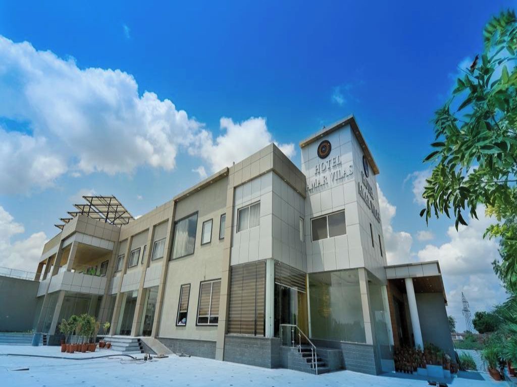 Un hôtel moderne doté d’un toit plat, d’une entrée centrale et d’une enseigne indiquant qu’il s’agit de l’« hôtel Mar Villas ».