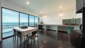 Una cocina moderna con vista al mar, un comedor con mesa y sillas, y una encimera de cocina con electrodomésticos.