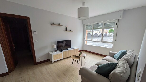 En stue med sofa, tv og et lille bord.