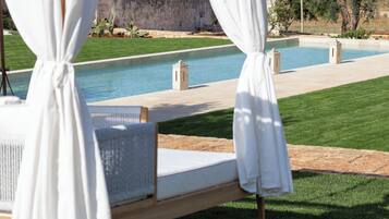 Een buitenzwembad en ligstoelen