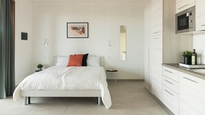 Un dormitorio moderno con una cama, una mesita de noche y una pequeña planta en maceta.