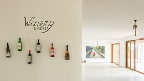 Una pared con el texto "Winery SINCE 1837" y cinco botellas de vino.
