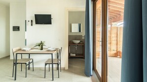 Un comedor con una mesa, sillas, una planta en maceta y un televisor en la pared.