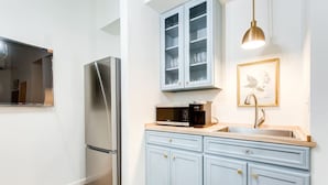 Una cocina moderna con refrigerador de acero inoxidable, microondas y armarios azul claro.
