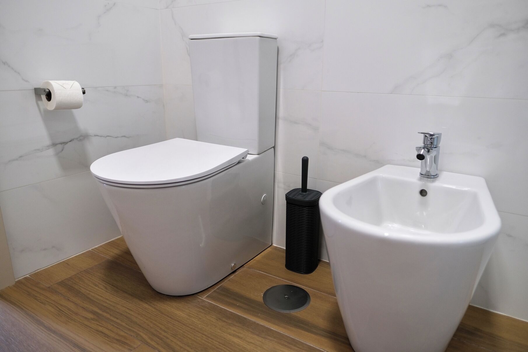 Une salle de bain moderne équipée de toilettes, d’un bidet et d’un lavabo.