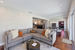 Una sala de estar moderna con un sofá modular, una mesa de centro y un comedor con mesa y sillas.