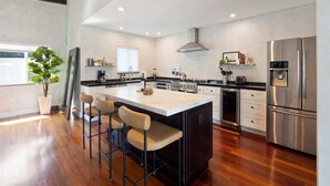 Una cucina moderna con isola centrale, elettrodomestici in acciaio inossidabile e pavimento in legno.