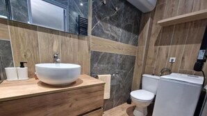 A modern bathroom with a wooden vanity, a white sink, and a toilet. - Appartement 3 (Viry-Châtillon)