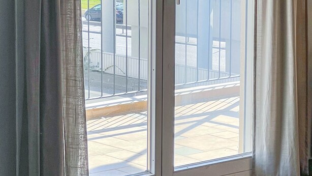 A room with a sliding glass door leading to a balcony with a view of the ocean. - Alimos Sea View Family Apartment (Alimos)