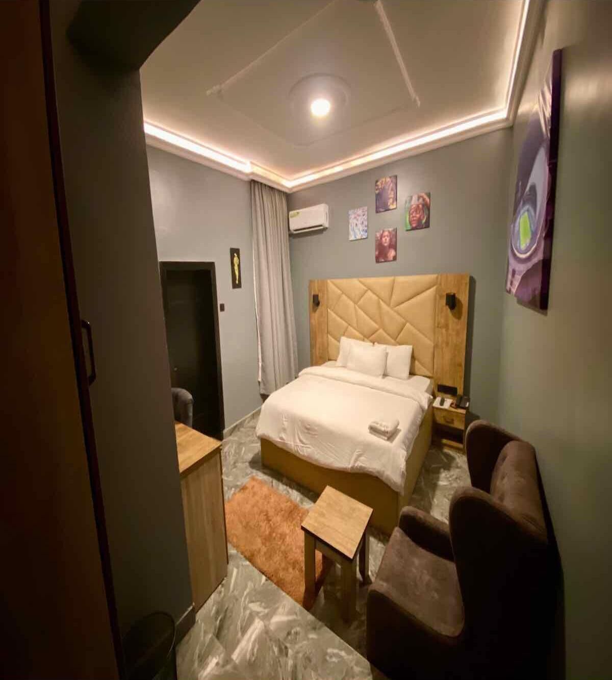 Une chambre d’hôtel avec un grand lit, un bureau, une chaise et une petite table.