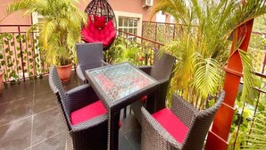 Un patio con mobiliario de mimbre y plantas en macetas.
