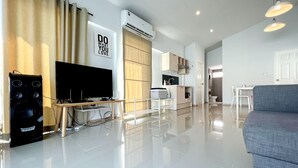 A modern living room with a flat-screen TV, a sound system, and a grey sofa. - GAO Akira Pool Villa (Ban Chang)