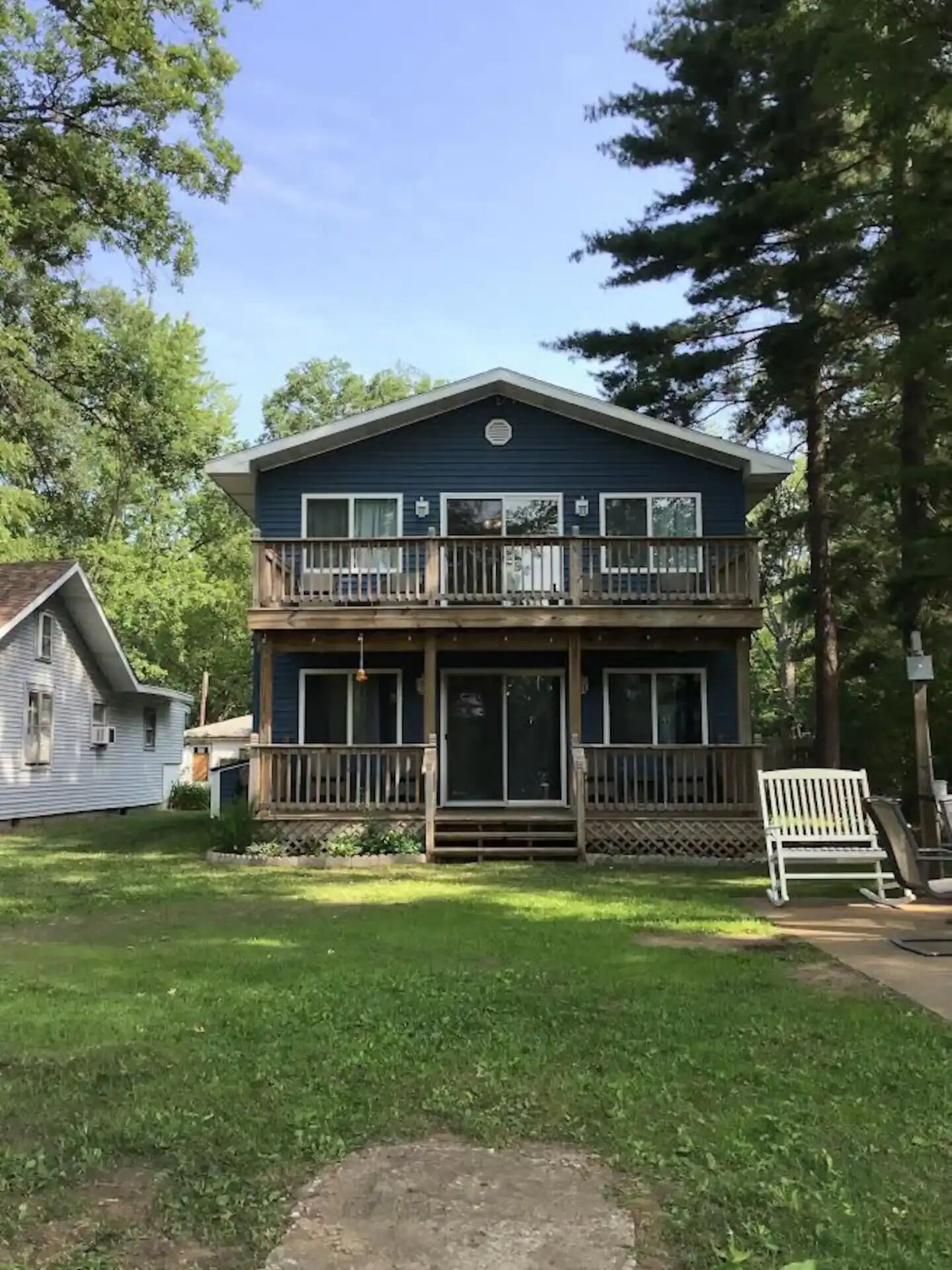 A two-story house with a balcony, a front porch, and a small front yard.