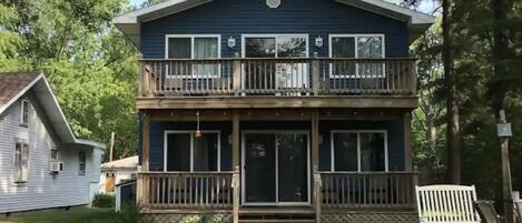 A two-story house with a balcony, a front porch, and a small front yard.