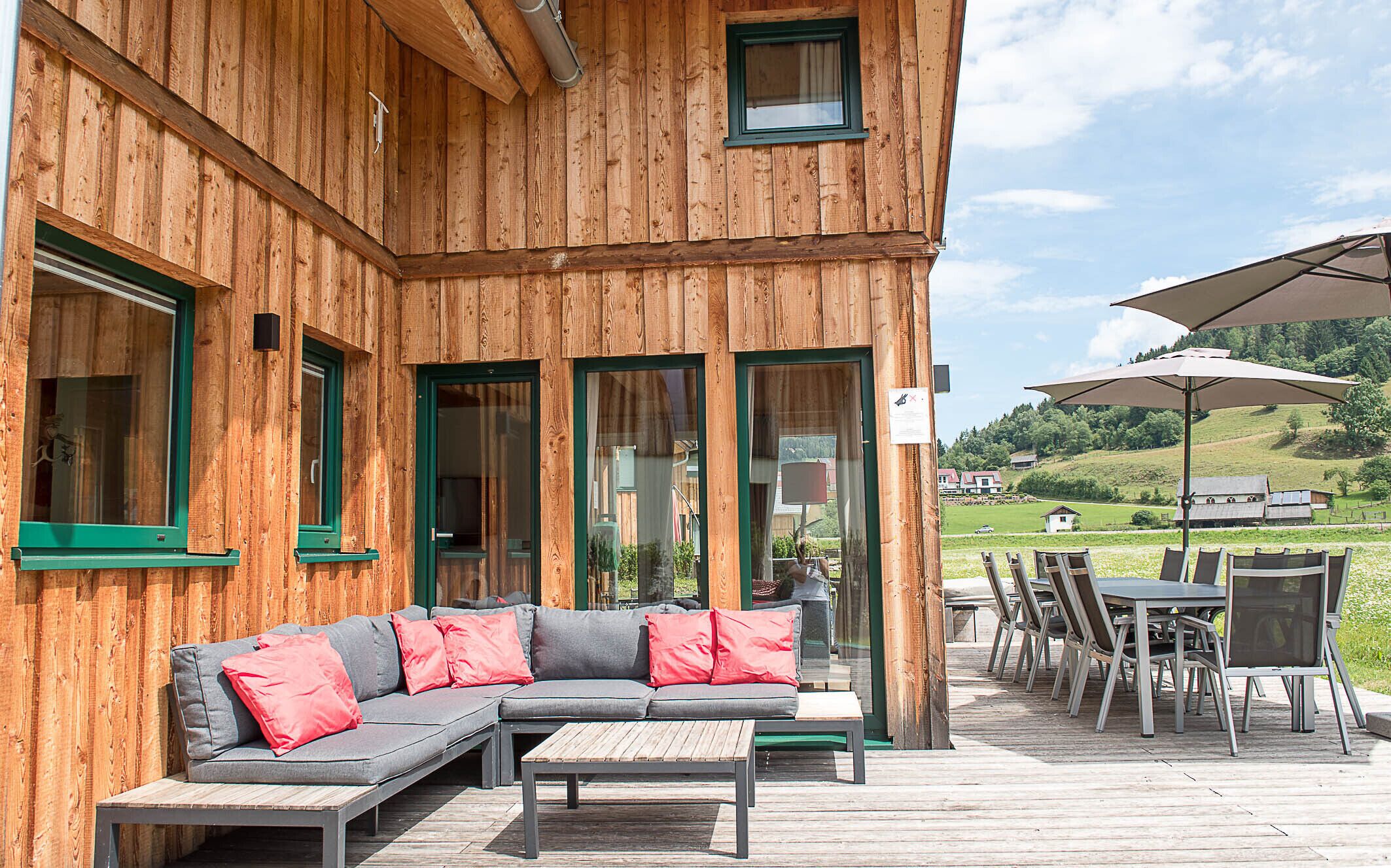 Un bâtiment en bois doté d’une terrasse, de sièges extérieurs et offrant une vue panoramique.