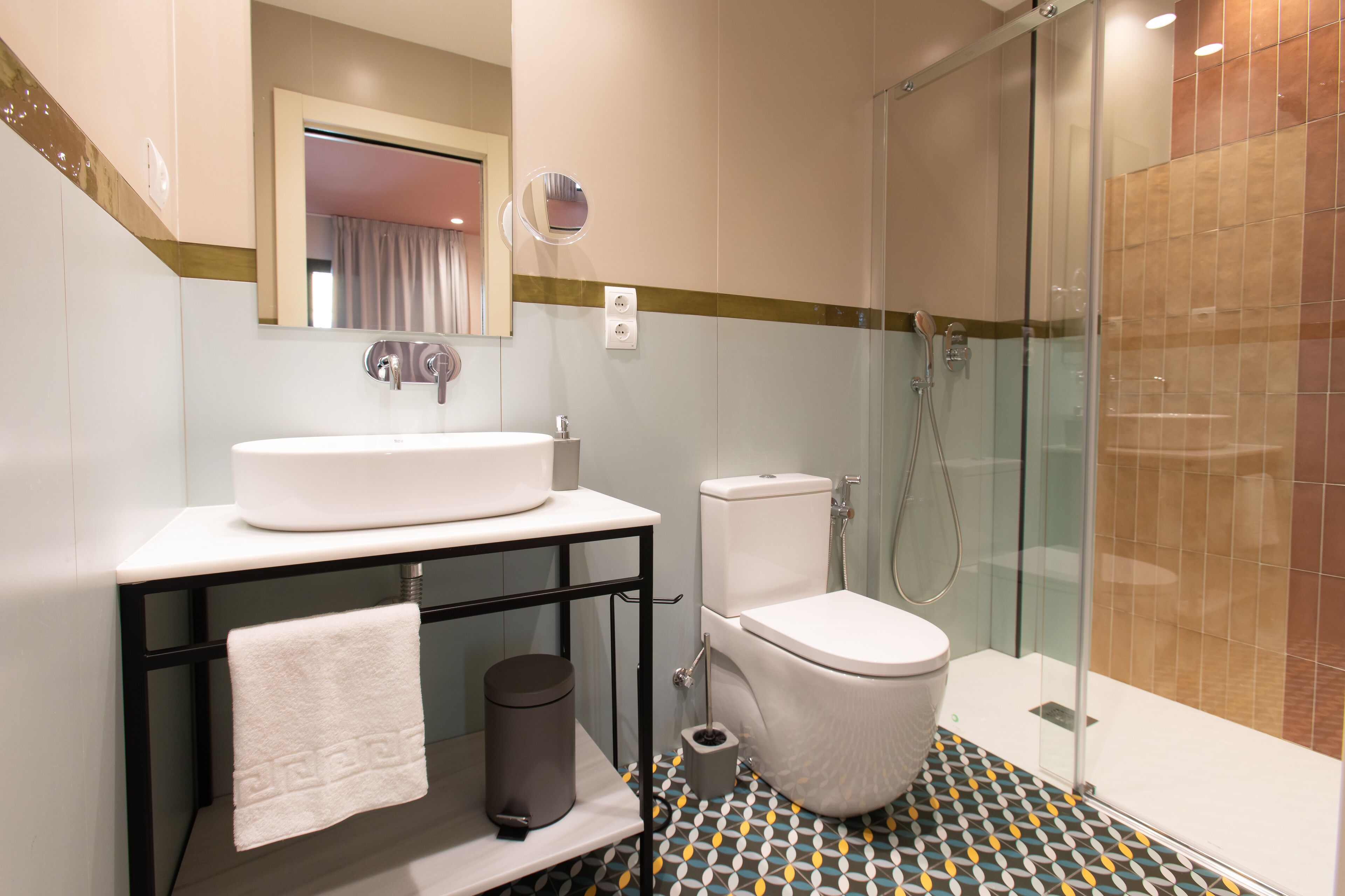 A bathroom with a white sink, toilet, and glass shower enclosure.