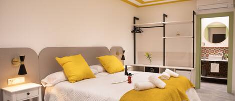 Un dormitorio ordenado con cama, mesitas de noche y un espejo.