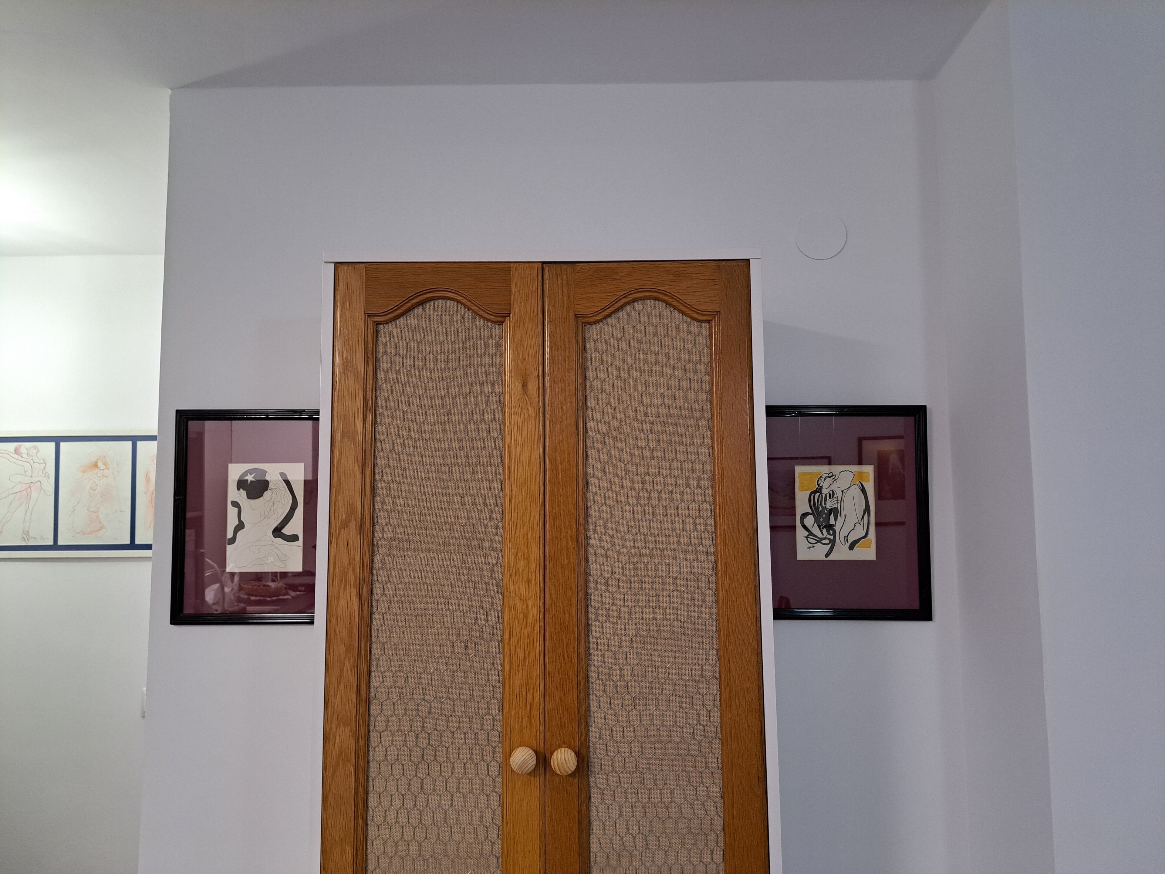 A wooden door with a textured panel and two round knobs.