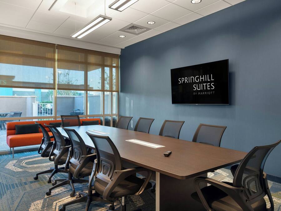 A conference room with a long table, chairs, and a large window.