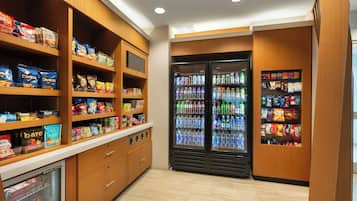 A snack and beverage area with shelves stocked with various snacks and a refrigerated section with bottled drinks.