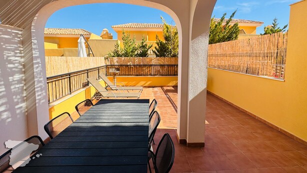 A covered outdoor seating area with a view of a residential neighborhood.