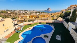 A swimming pool with a view of the ocean and a town in the background.