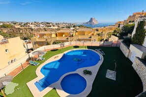 A swimming pool with a view of the ocean and a town in the background.