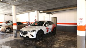 A parking garage with a white car parked in a spot marked with the number 20.
