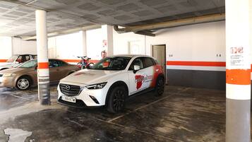 Un parking où une voiture blanche est garée sur une place marquée du numéro 20.