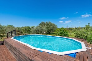 A rectangular swimming pool with a wooden deck, surrounded by greenery and trees. - Trullo Nicolo With Pool Martina Franca (Martina Franca)