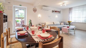 A dining area with a round table set for four, a sofa, and a small coffee table. - House Dijana Pool & Garden (Bloke)