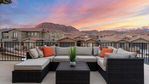 A balcony with a sectional sofa, a potted plant, and a coffee table. - Double The Fun 7 Bedroom Home (Ivins)