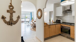 Una cocina moderna con armarios de madera, horno de acero inoxidable y microondas.