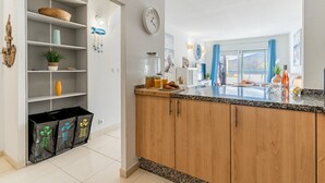 Una cocina con armarios de madera, encimera de granito, un reloj y una ventana con vistas.