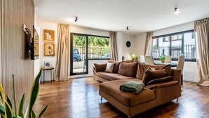 A living room with a brown sofa, a dining table with chairs, and a large window with curtains. - Centric and bright apartment - Puerto de La Cruz (Puerto de la Cruz)