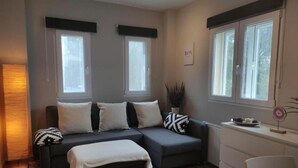 A modern living room with a sectional sofa, a small table, and a window with a view. - Estudio Premium Sierra Nevada (Sierra Nevada)