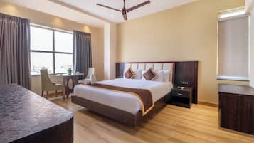 A modern hotel room with a large bed, a desk, and a chair.