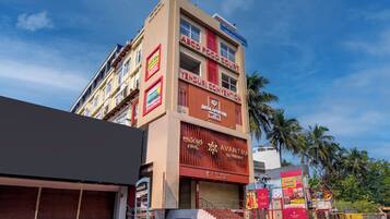 Un edificio de varios pisos con letreros que indican 'Monday Hotel', 'ABC Food Court', 'Yenduri Convention' y 'Avantha by Aishwarya'.