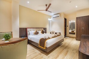 Una habitación de hotel moderna con una cama grande, un escritorio y un ventilador de techo.