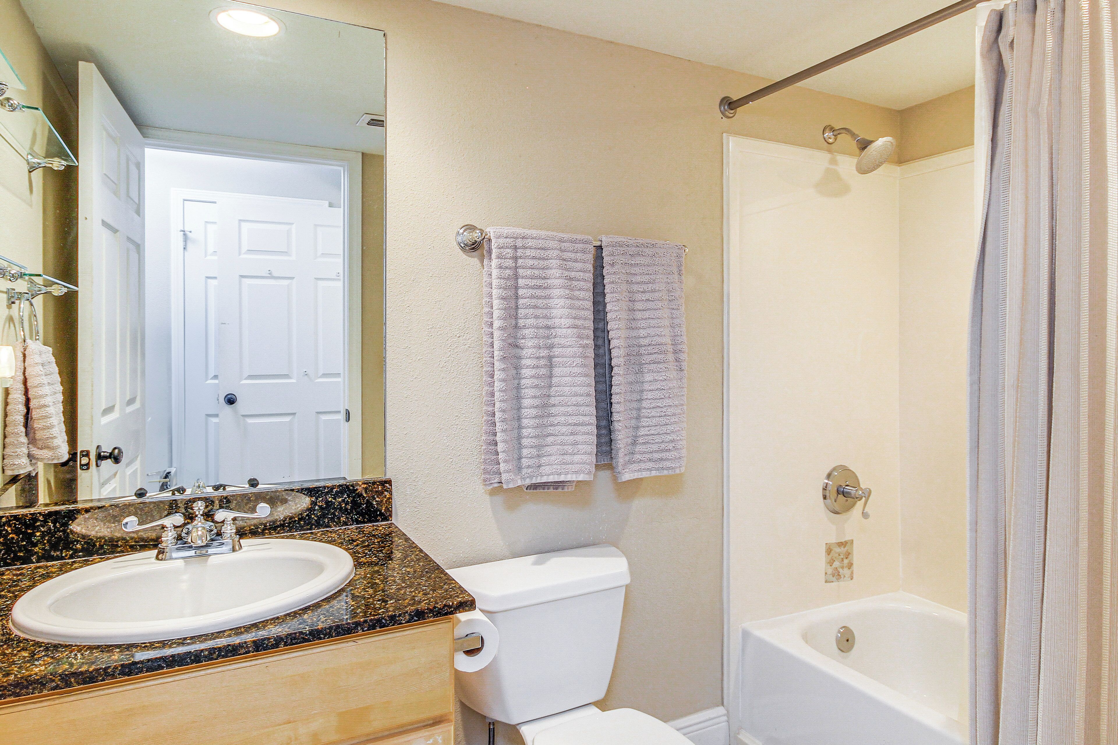 A bathroom with a sink, toilet, and bathtub.