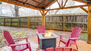 A covered patio with a fire pit and four Adirondack chairs. - Mebane Home w/ Private Yard: Steps to Downtown! (Mebane)