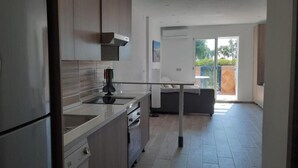 A modern kitchen with stainless steel appliances, a central island, and a view to a balcony. - Studio PREMIUM Vera Playa Naturist  (Vera)