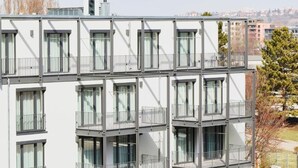 Ein modernes, mehrstöckiges Gebäude mit Balkonen und großen Fenstern.