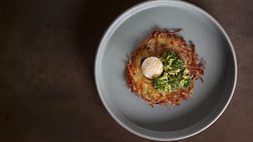 A plate with a food item on a dark surface.