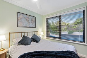A bedroom with a bed, a world map on the wall, and a window with blinds. - 5BR and pool luxury home (Kinross)