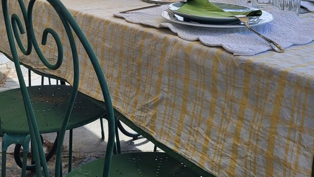 An outdoor dining area with a table set for two, overlooking a scenic view.