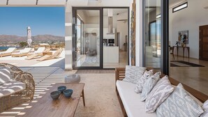 Een moderne villa met zonneterras, een eethoek en een keuken.